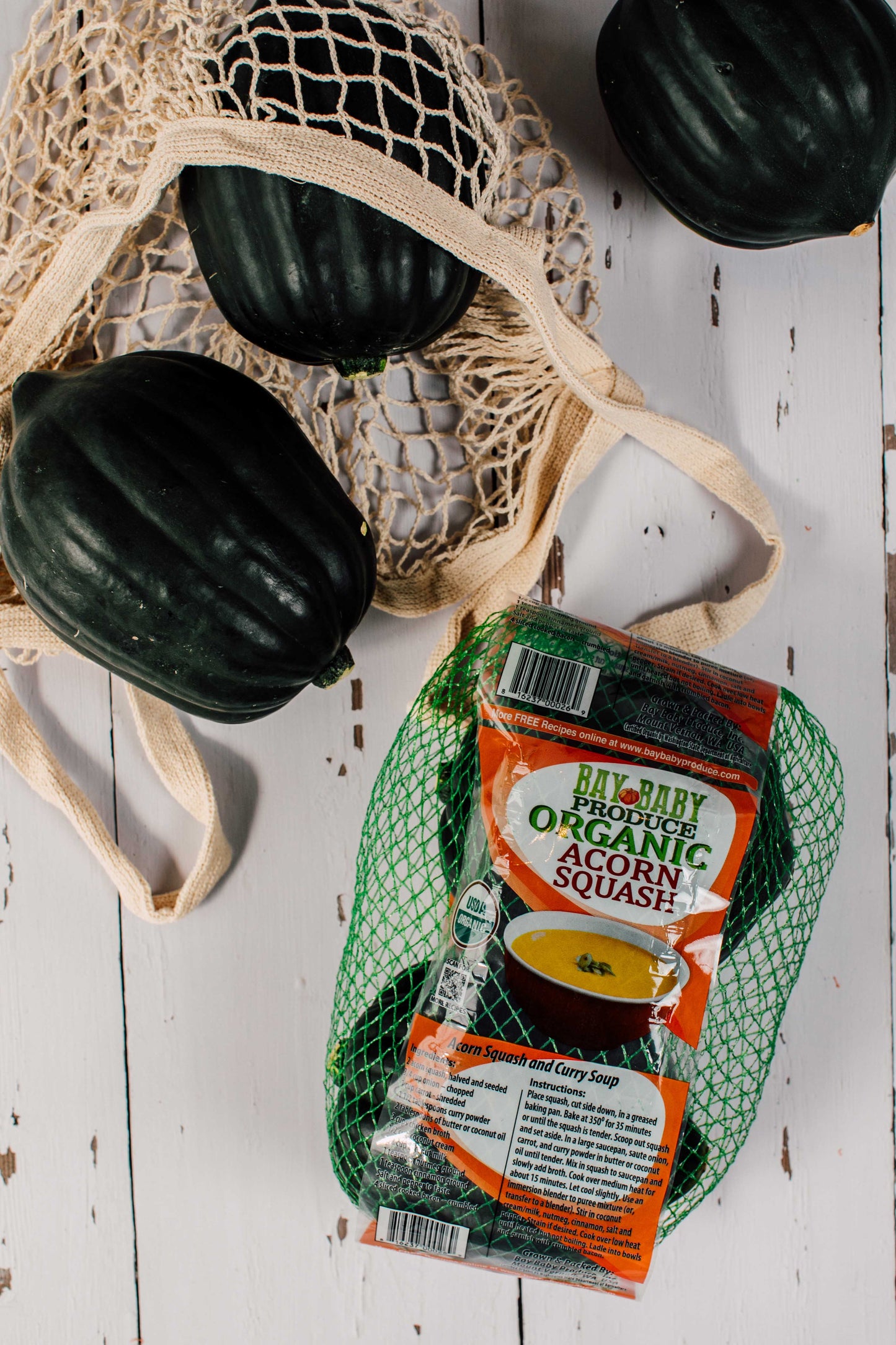 Acorn squash with a package of organic acorn squash soup on a wooden surface