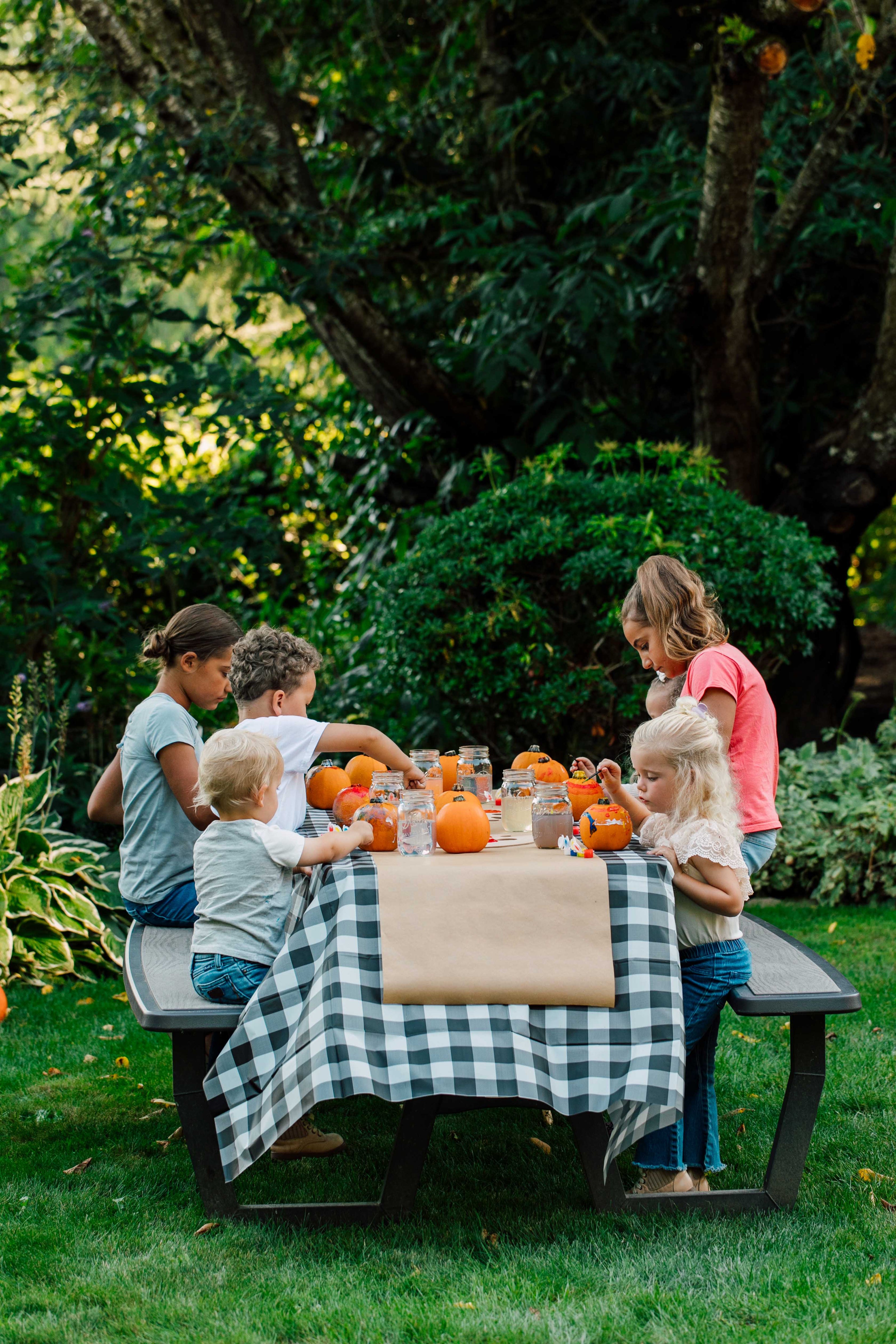 Children around a table with pumpkins in an outdoor setting